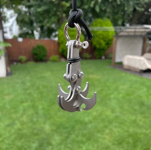 Beckett grappling hook with metal claws and sturdy rope, designed for climbing or outdoor utility, shown hanging against a neutral background.