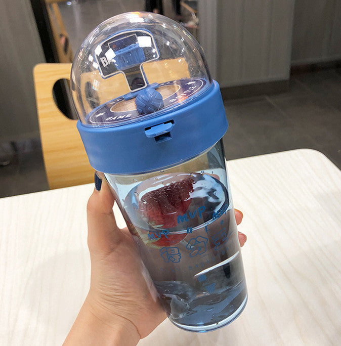Beckett™ basketball-shaped water bottle with black lid and orange body, featuring basketball texture and branding detail.